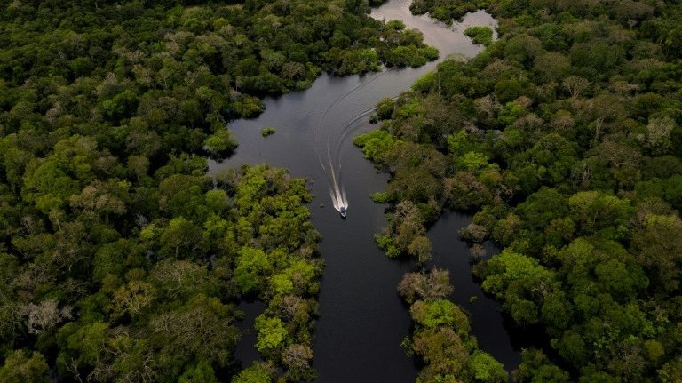 Barco navega no rio Juruá, na Reserva de Desenvolvimento Sustentável Uacari, no coração da Amazônia brasileira - Crédito: AFP
