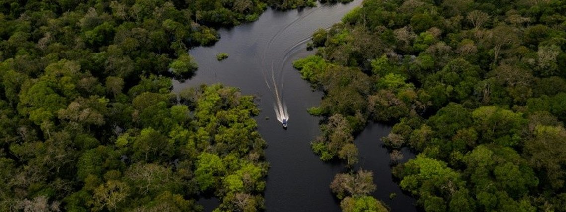 Barco navega no rio Juruá, na Reserva de Desenvolvimento Sustentável Uacari, no coração da Amazônia brasileira - Crédito: AFP